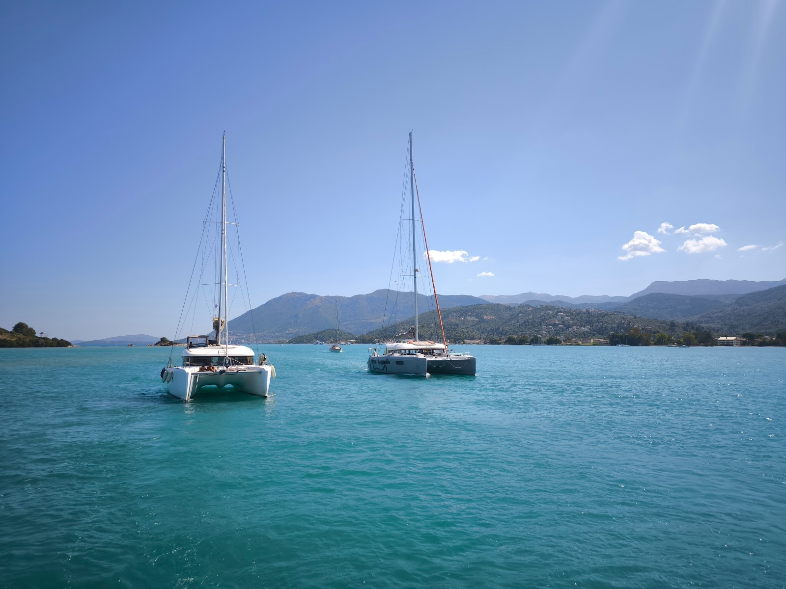 Two catamarans anchored in a turquoise bay off Lefkada, Greece