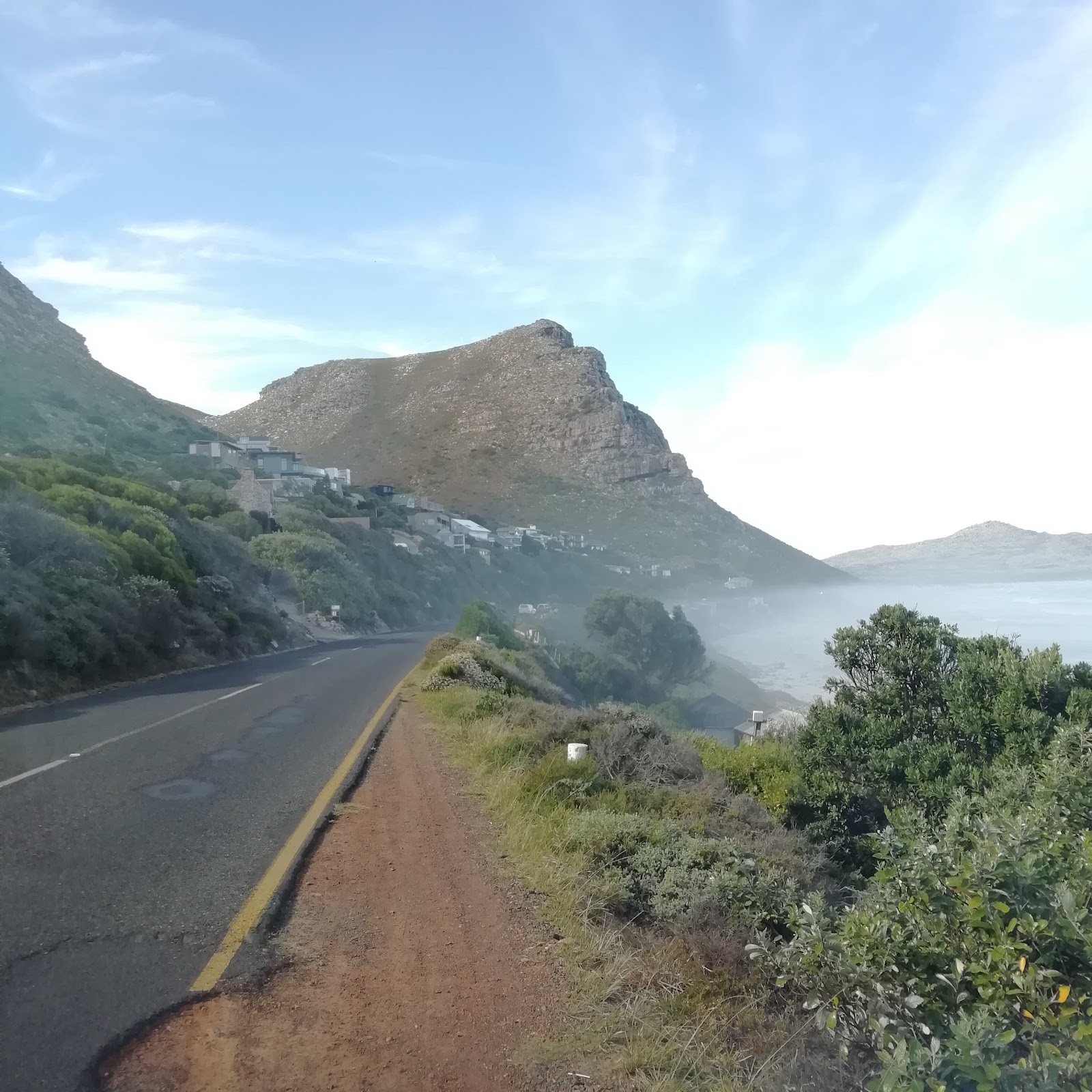 Coastal mountain scenery with cliffside houses on the Cape Peninsula scenic drive
