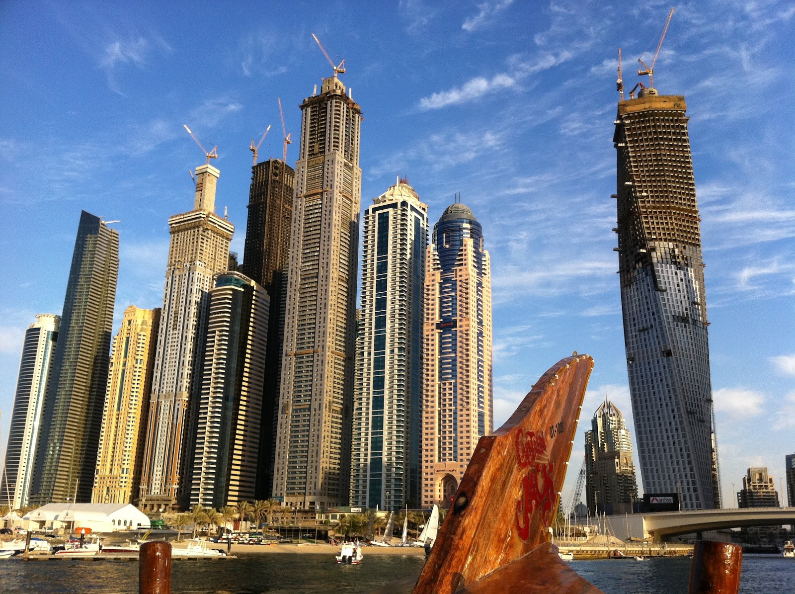 Dubai Marina towers above the prow of a traditional wooden dhow